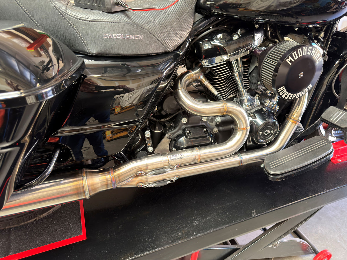 Irish Pig Performance Harley-Davidson Road Glide full-length 2-into-1 exhaust showing stainless-steel primary routing and collector on Milwaukee-Eight engine