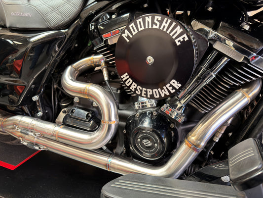 Close-up of Irish Pig Performance Harley-Davidson Road Glide full-length 2-into-1 exhaust showing stainless-steel stepped primaries on Milwaukee-Eight engine